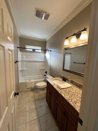 A bathroom with a sink , toilet , bathtub and mirror.