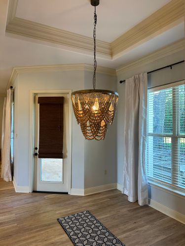 There is a chandelier hanging from the ceiling in the middle of the room.