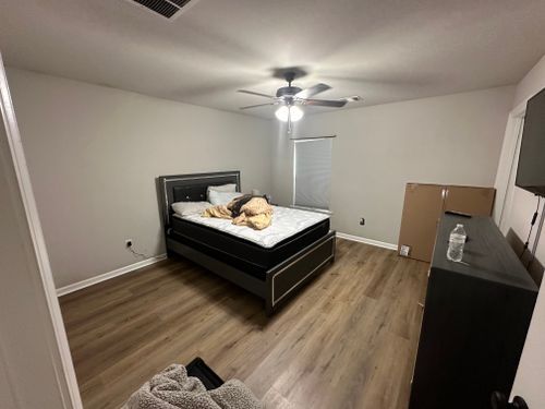A bedroom with a bed and a ceiling fan.