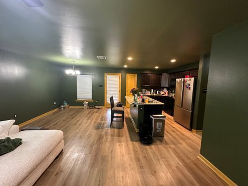 A living room with a couch and a kitchen in the background.