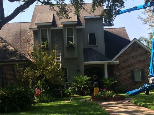 A large brick house with a crane in front of it.