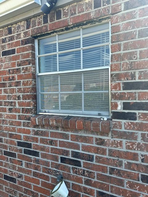 Window in brick wall with blinds.