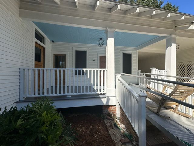 White porch with blue ceiling, ramp access.