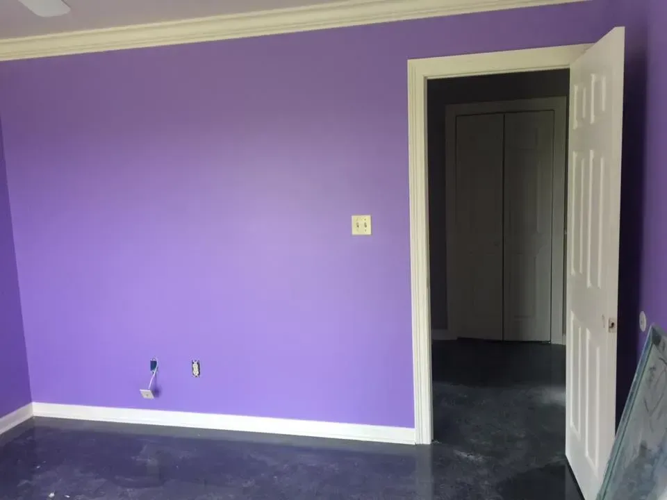 A room with purple walls and a white door