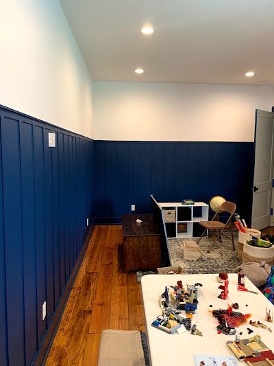 A room with blue walls , wooden floors , a table and chairs.