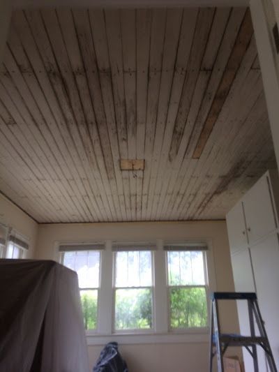 A room with a wooden ceiling and a ladder