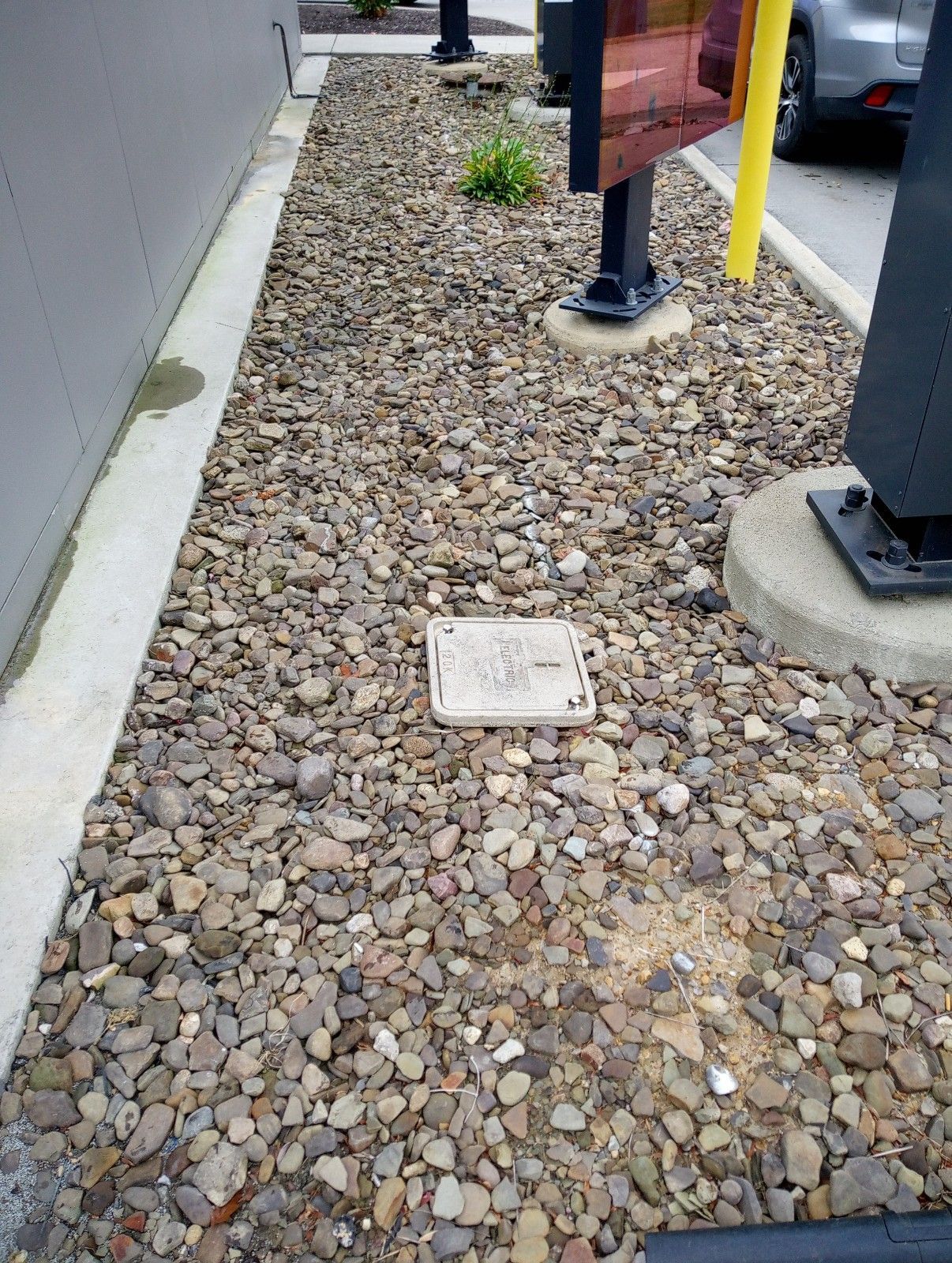 A sidewalk filled with rocks and gravel next to a building.