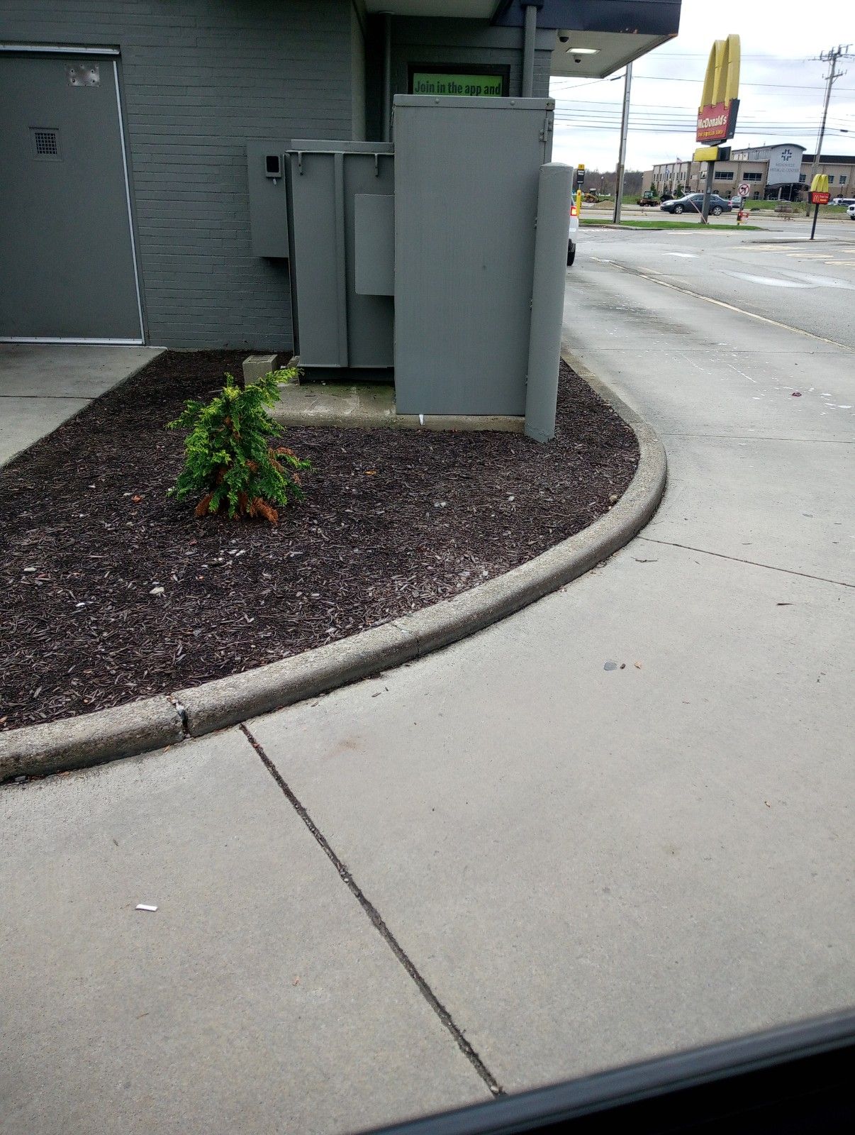 A mcdonald 's drive thru is located on the side of the road.