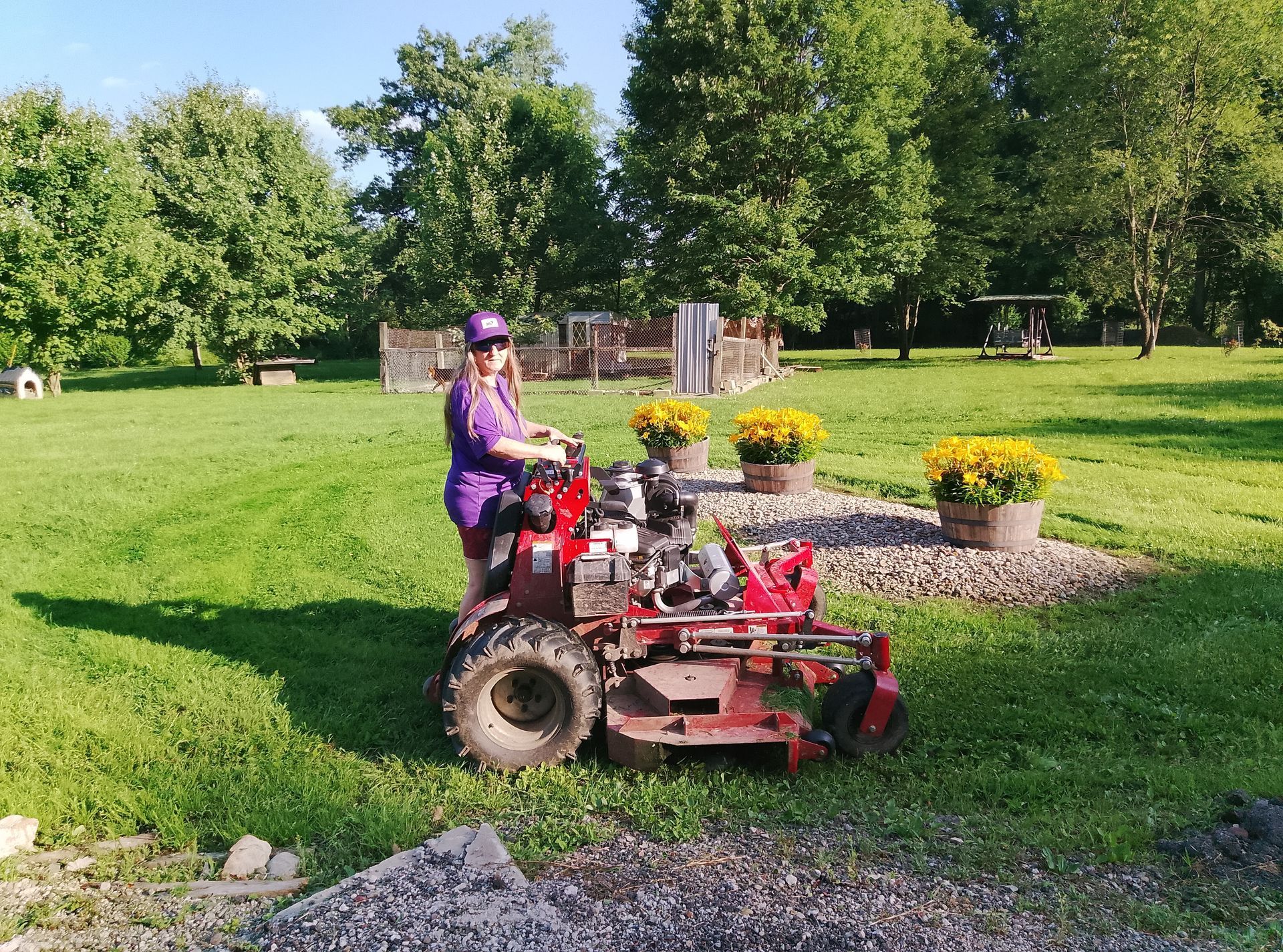 A person is riding a tractor through a grassy field.