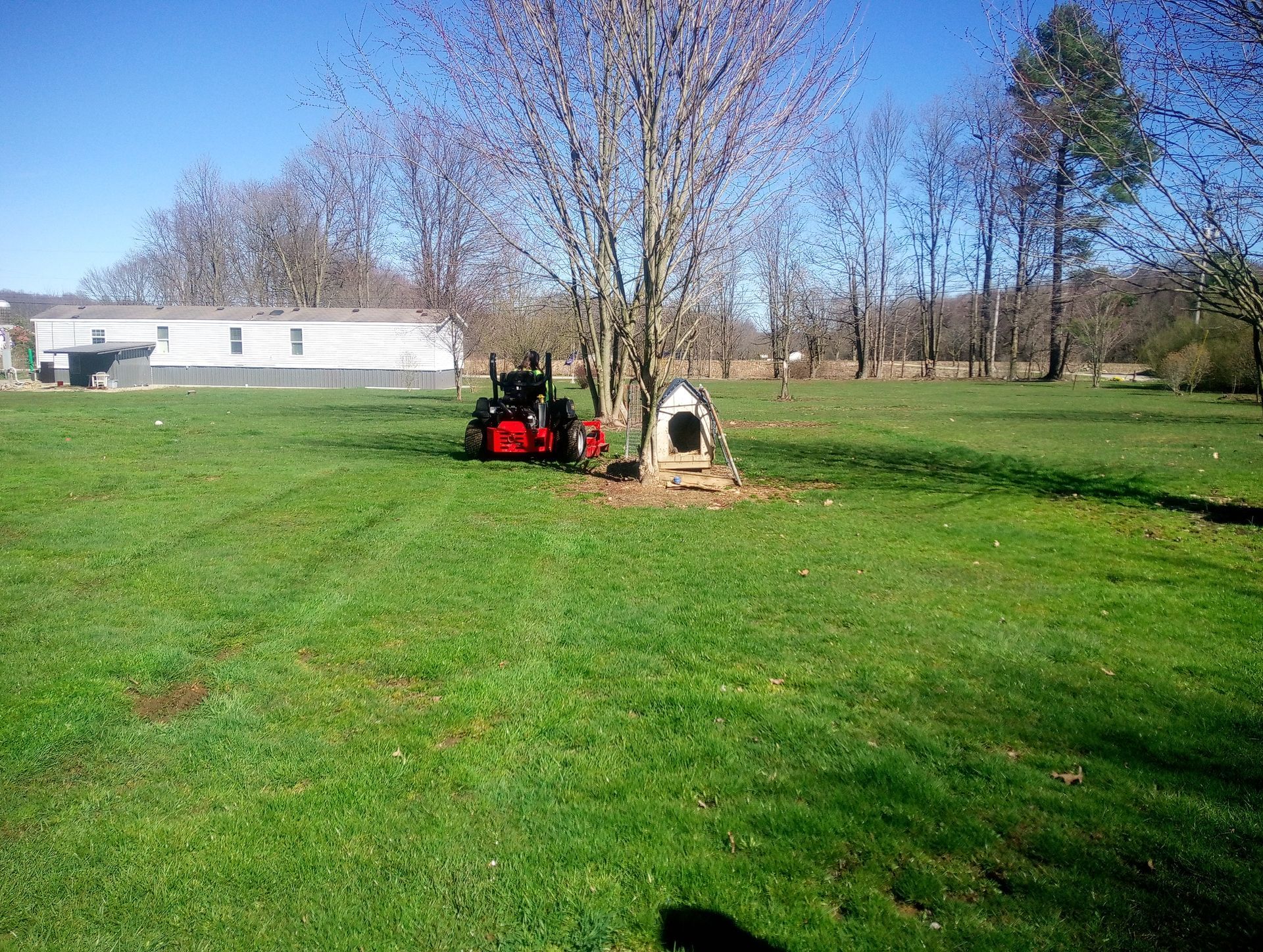 A lawn mower is sitting in the middle of a lush green field.