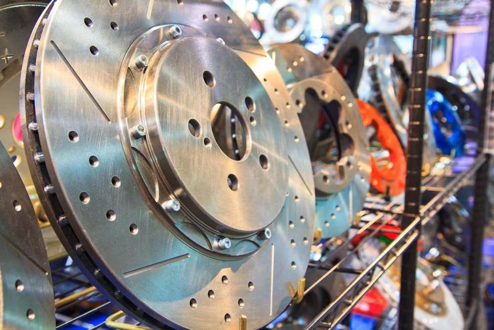 A Bunch Of Brake Rotors Are Sitting On A Shelf In A Store — Macquarie Brake & Automotive Services In Lake Cathie, NSW