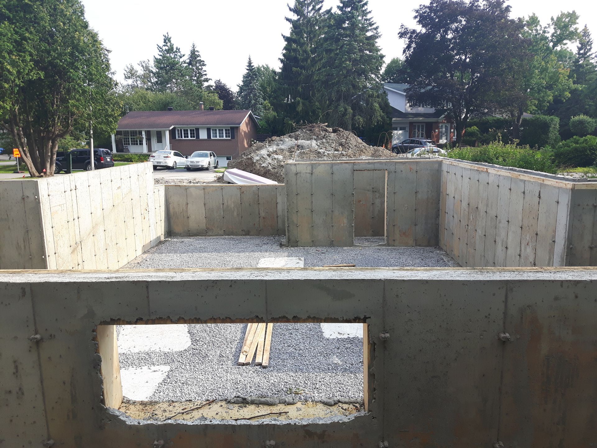 Un mur en béton avec un trou et une maison en arrière-plan