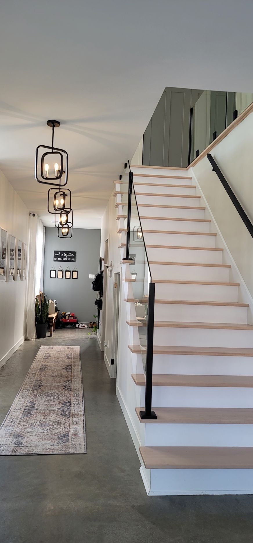 Un couloir avec des escaliers menant au deuxième étage d'une maison.