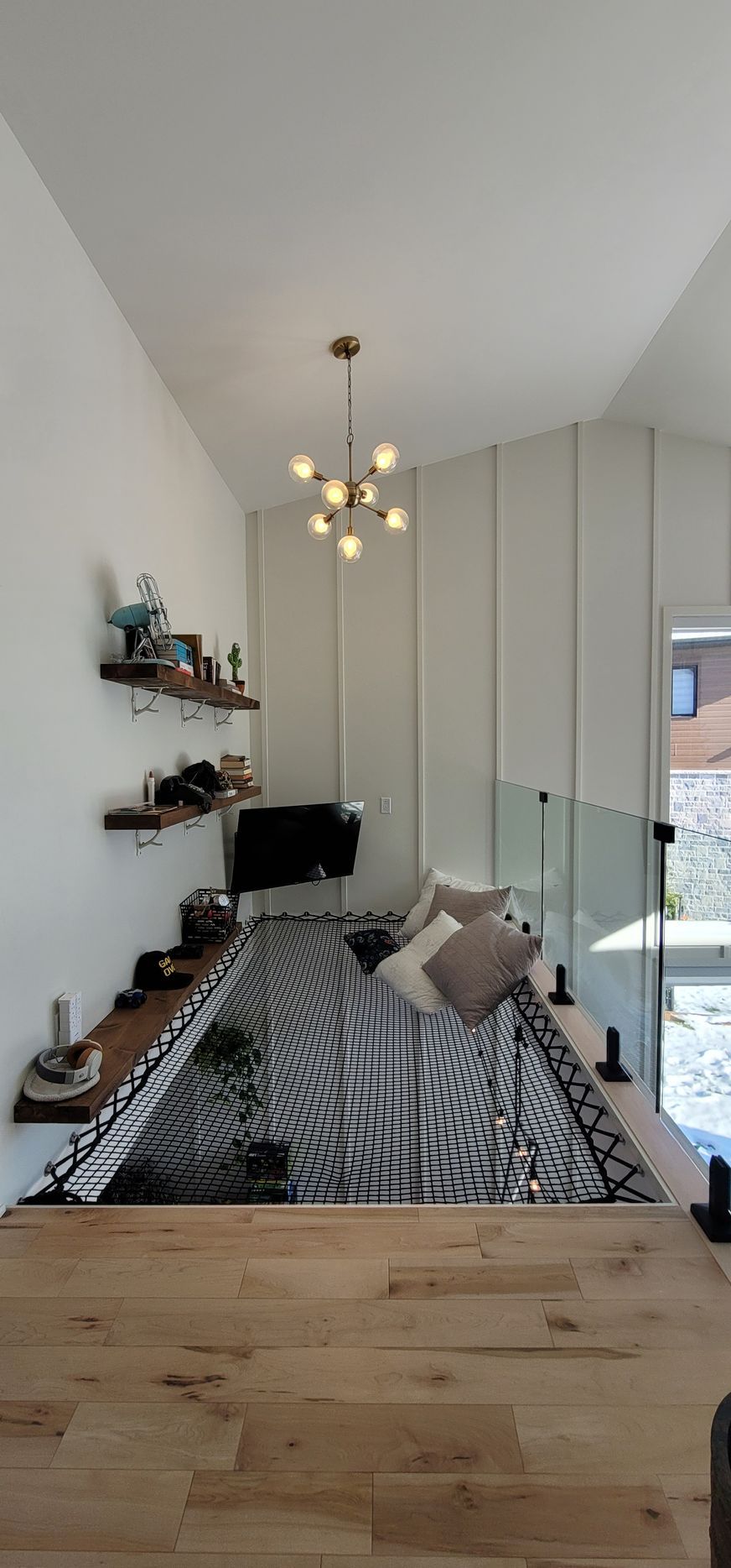 Un salon avec un canapé, une table, des étagères et un lustre.