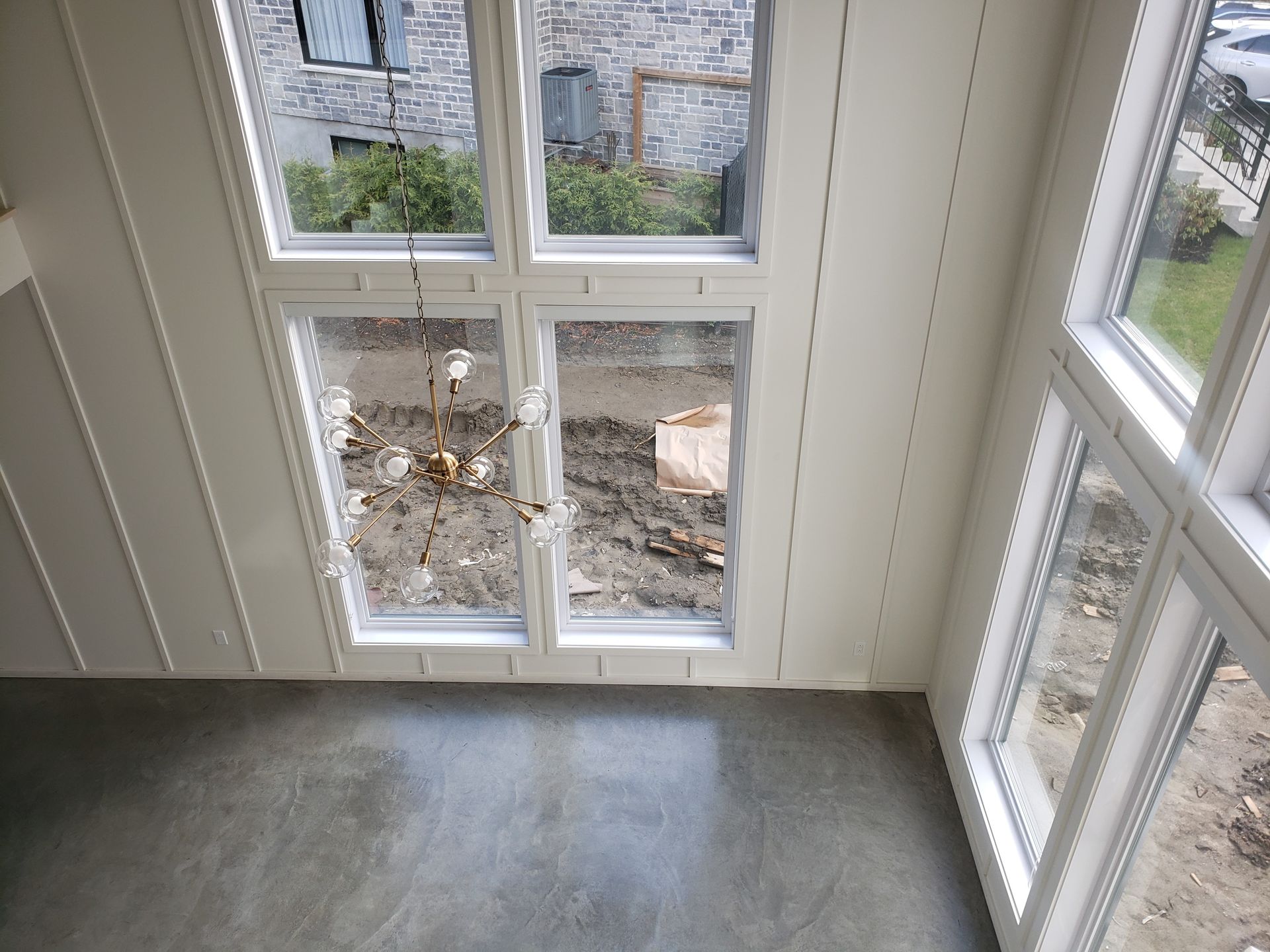 Une pièce avec beaucoup de fenêtres et un sol en béton