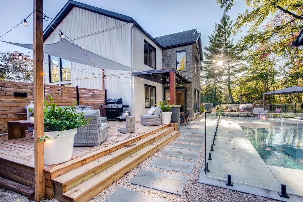 Une grande maison avec piscine et terrasse en bois.