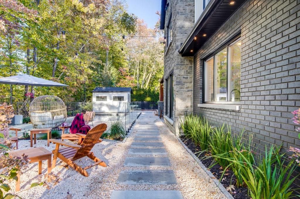Une maison en briques avec un patio et des chaises devant.