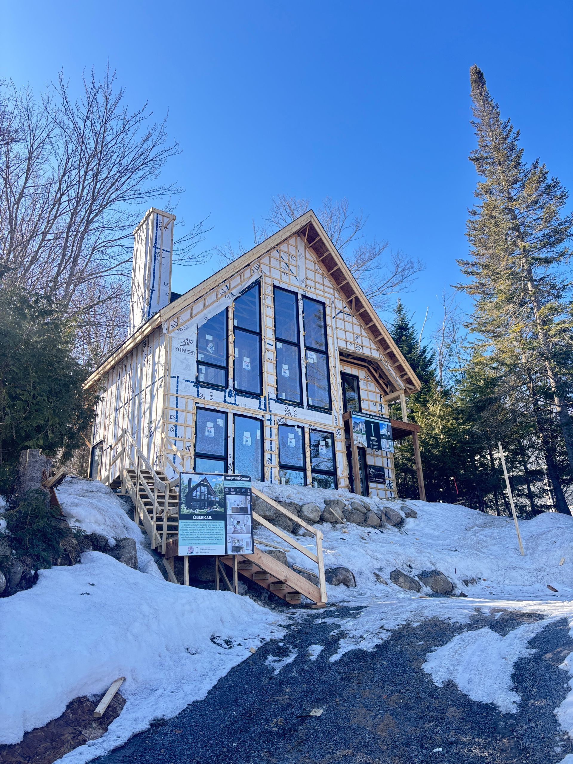 Une maison est en construction au sommet d'une colline couverte de neige.