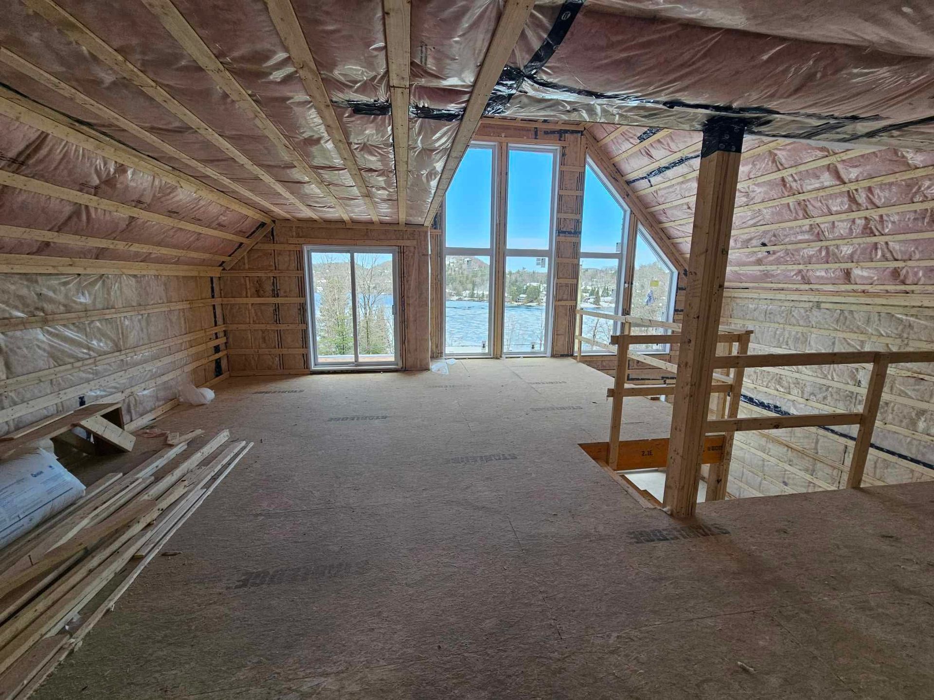 Une pièce vide avec beaucoup de fenêtres et un escalier.