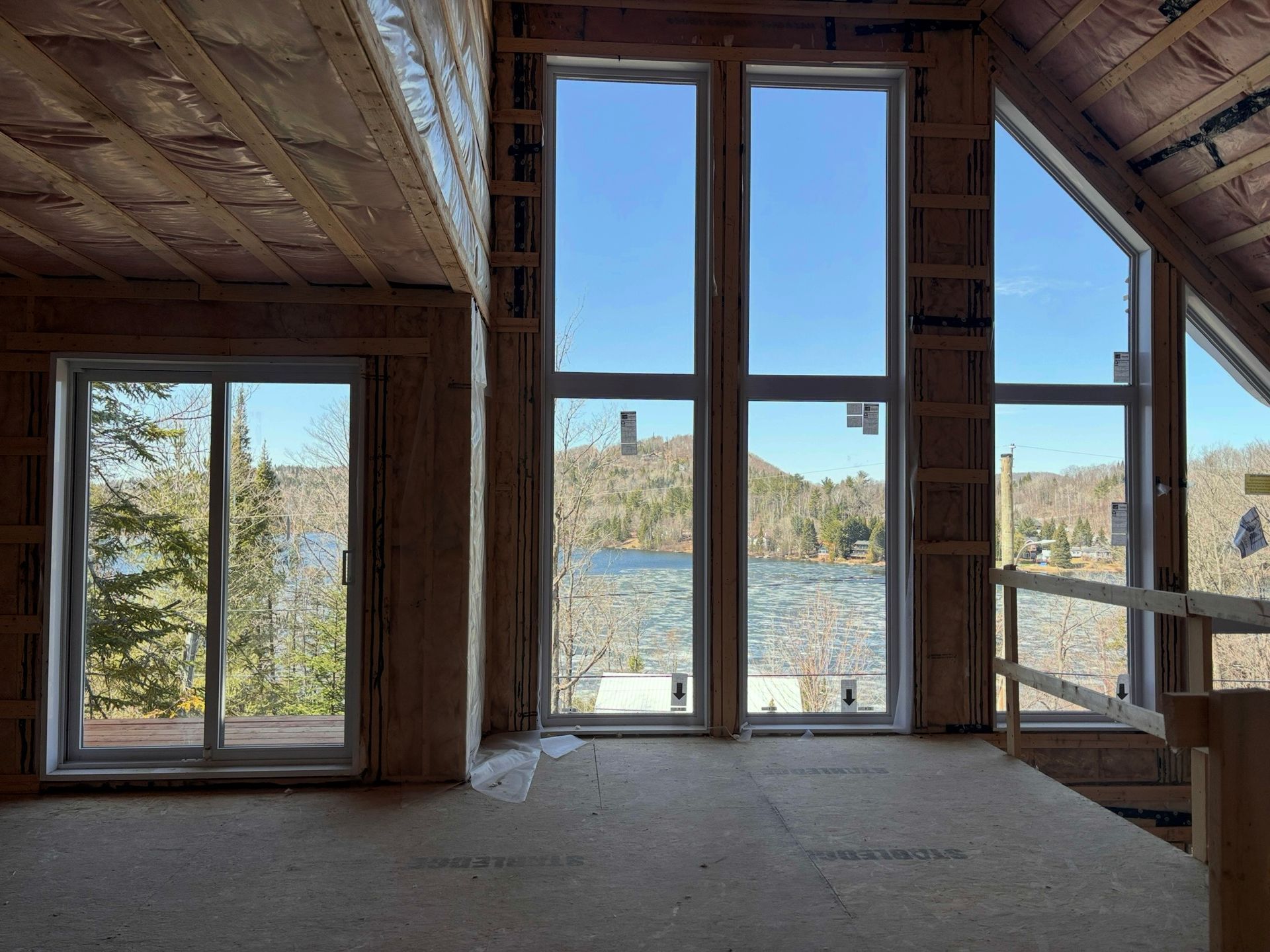 Une pièce avec beaucoup de fenêtres et une vue sur un lac