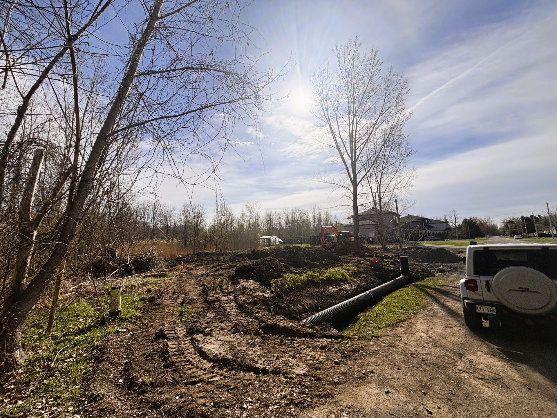 Une jeep est garée sur le bord d'un chemin de terre.