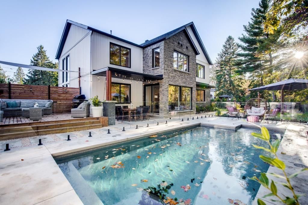 Une grande maison avec une grande piscine devant.