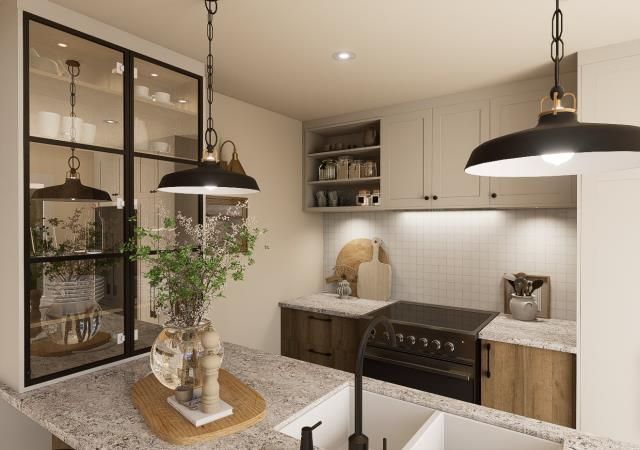 Une cuisine avec un évier, une cuisinière, des armoires et des lampes suspendues au plafond.