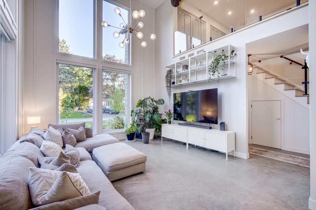 Un salon avec un canapé, une télévision et des escaliers.