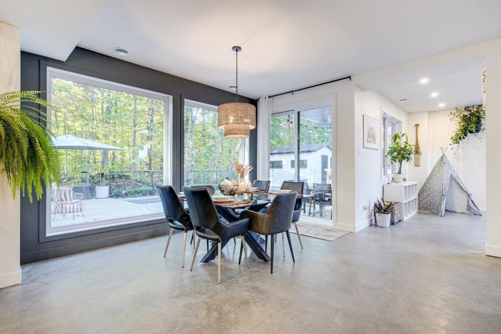 Une salle à manger avec une table et des chaises et une grande fenêtre.