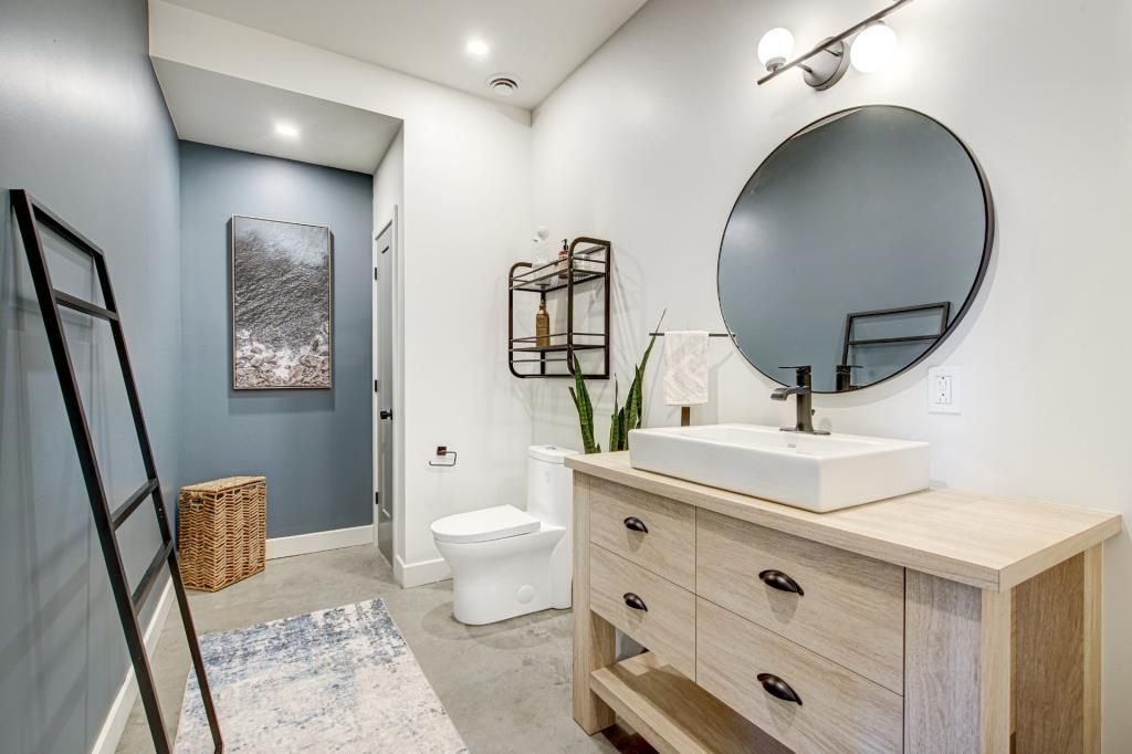Une salle de bain avec WC, lavabo et miroir.