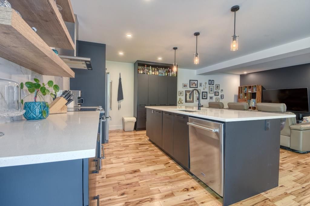 Une cuisine avec un grand îlot et des électroménagers en acier inoxydable.