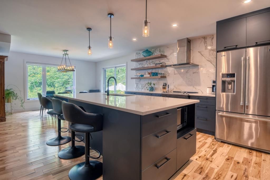 Une cuisine avec électroménagers en acier inoxydable et un grand îlot.