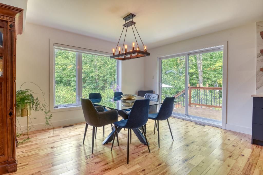Une salle à manger avec une table et des chaises et un lustre.