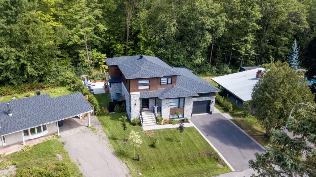 Une vue aérienne d'une grande maison entourée d'arbres.