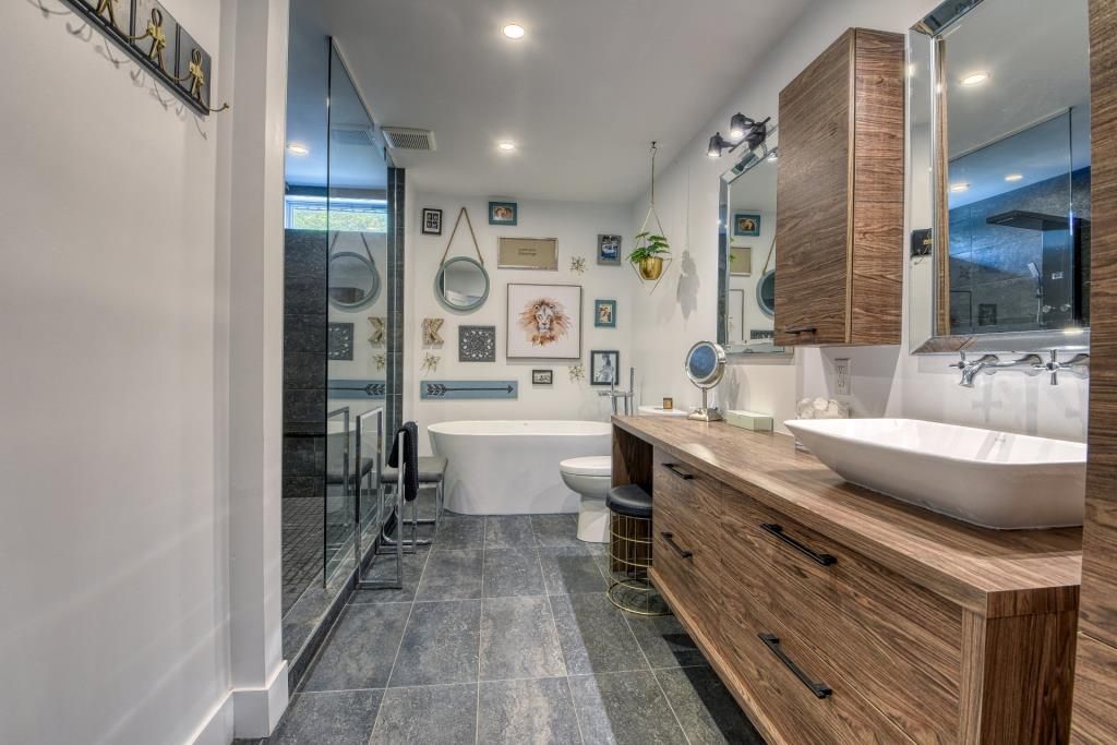 Une salle de bain avec deux lavabos, une baignoire et un miroir.