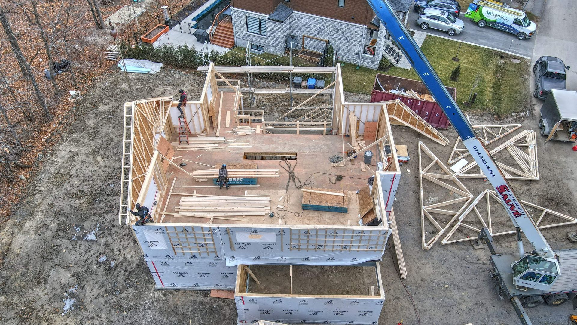 Une vue aérienne d'une maison en construction avec une grue en arrière-plan.