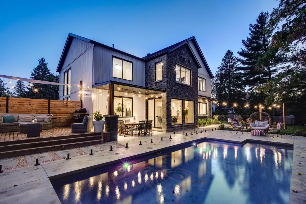 Une grande maison avec une piscine devant.