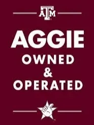Maroon sign with "Aggie Owned & Operated" text, Texas A&M logo, and a hand giving the "Gig 'em" salute.