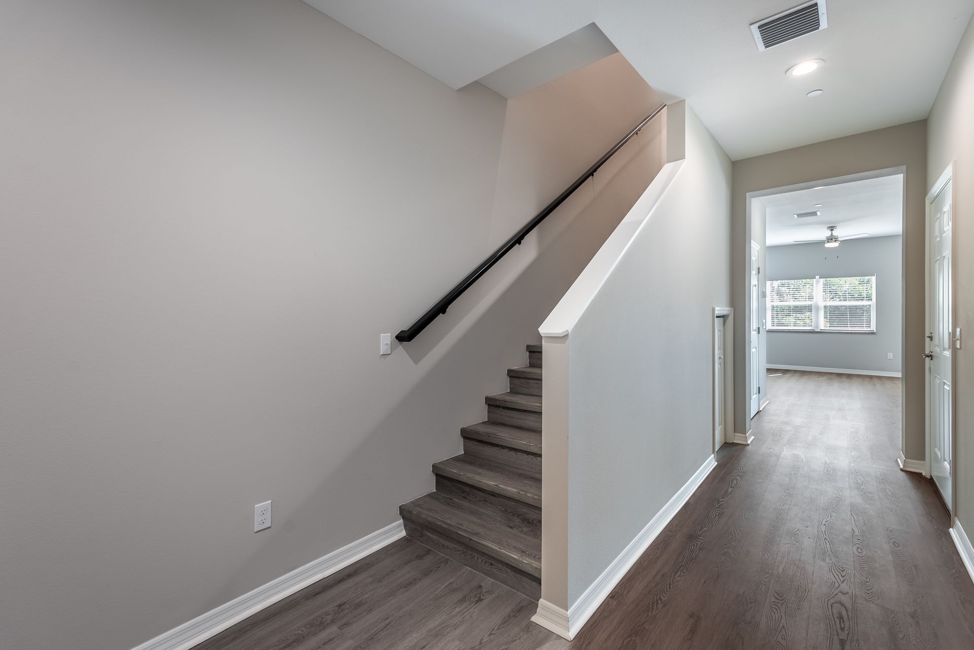 a hallway with stairs leading up to the second floor of a townhouse