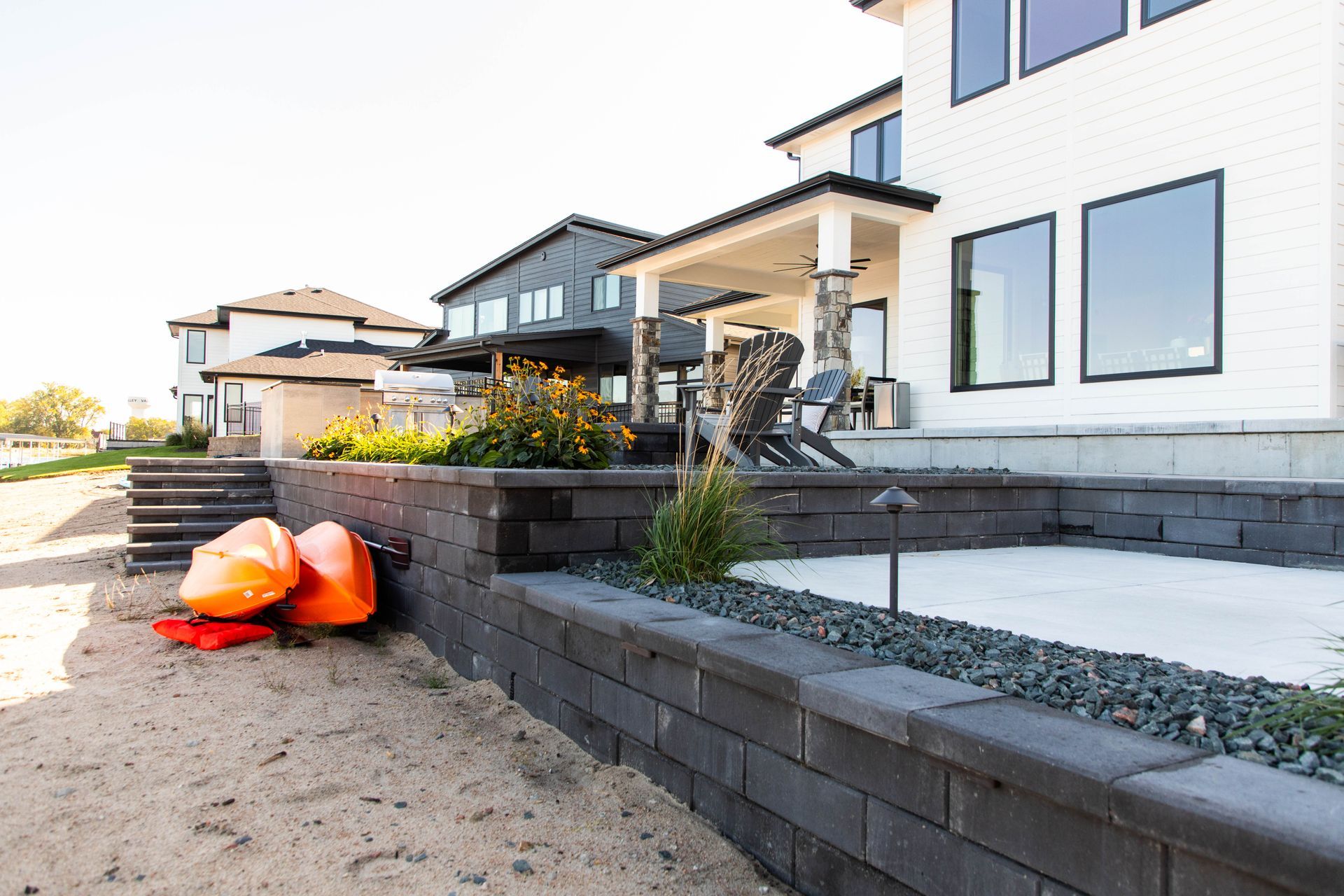 A couple of kayaks are sitting on the ground in front of a house.