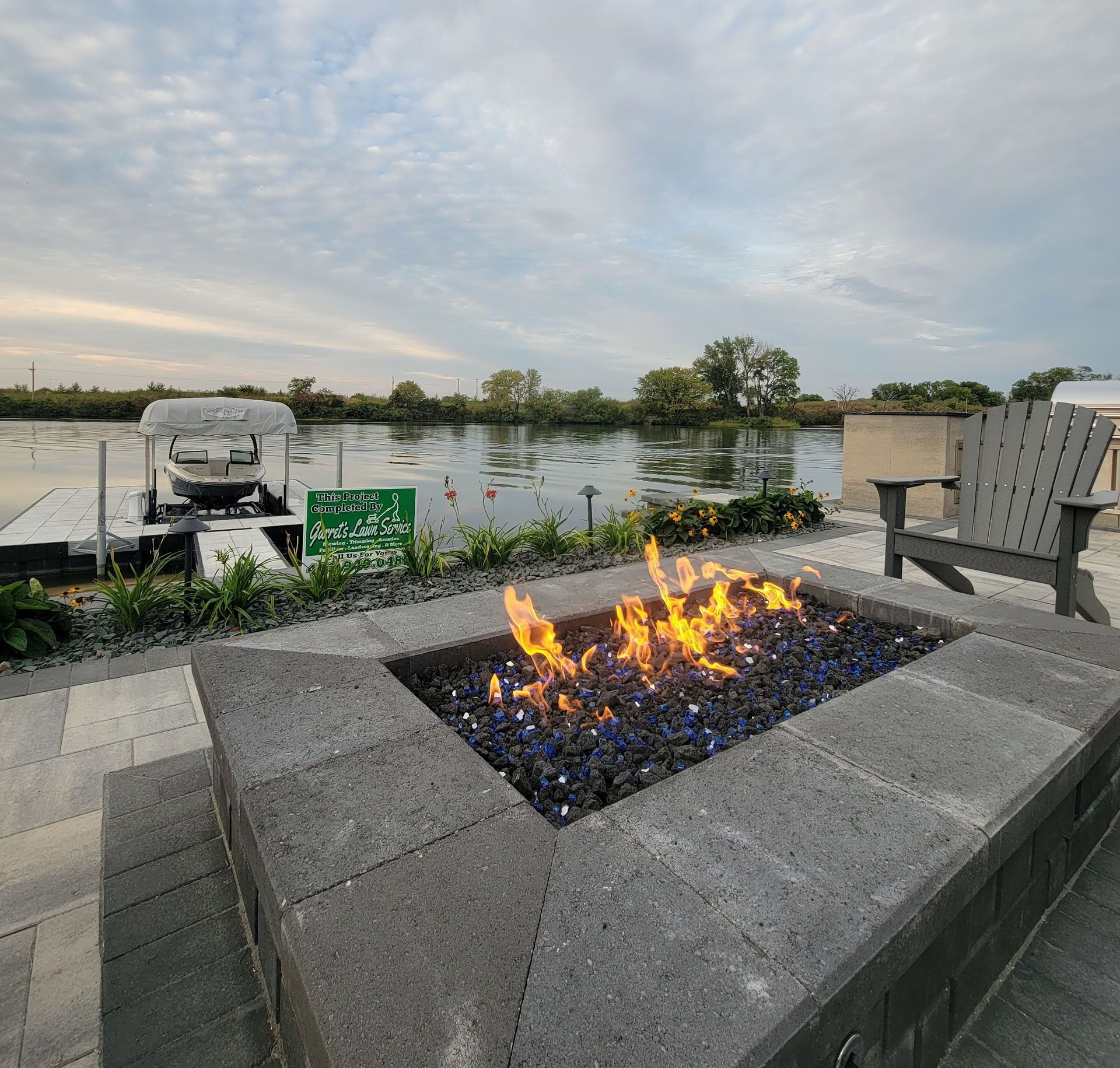 A fire pit with a boat in the background