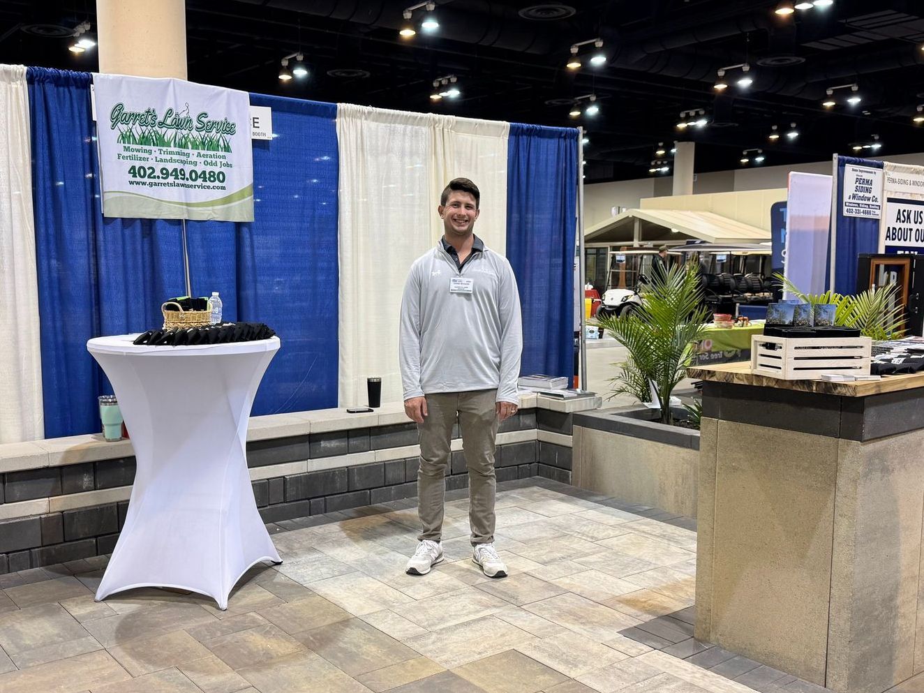 A man is standing in front of a table at a convention.