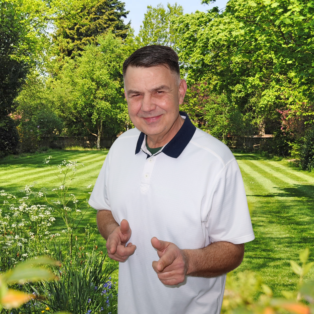 A man in a white shirt is giving a thumbs up