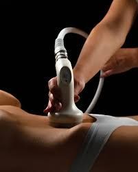 A practitioner uses a handheld ultrasound device on a client's neck during a non-surgical skin tightening treatment.