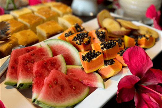 Um prato branco coberto com fatias de melancia e mamão.