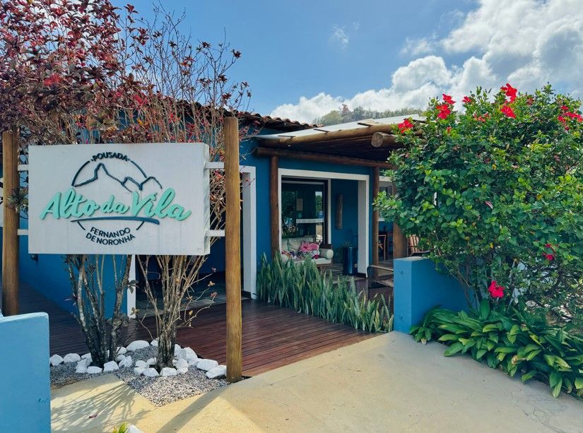 Um prédio azul com uma placa que diz alto da vila