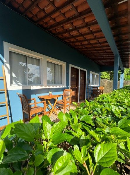 Uma casa azul com uma mesa e cadeiras na varanda