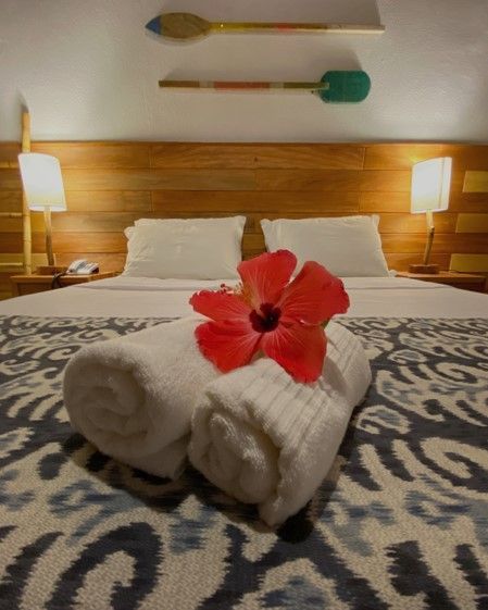 Uma cama com toalhas e uma flor nela