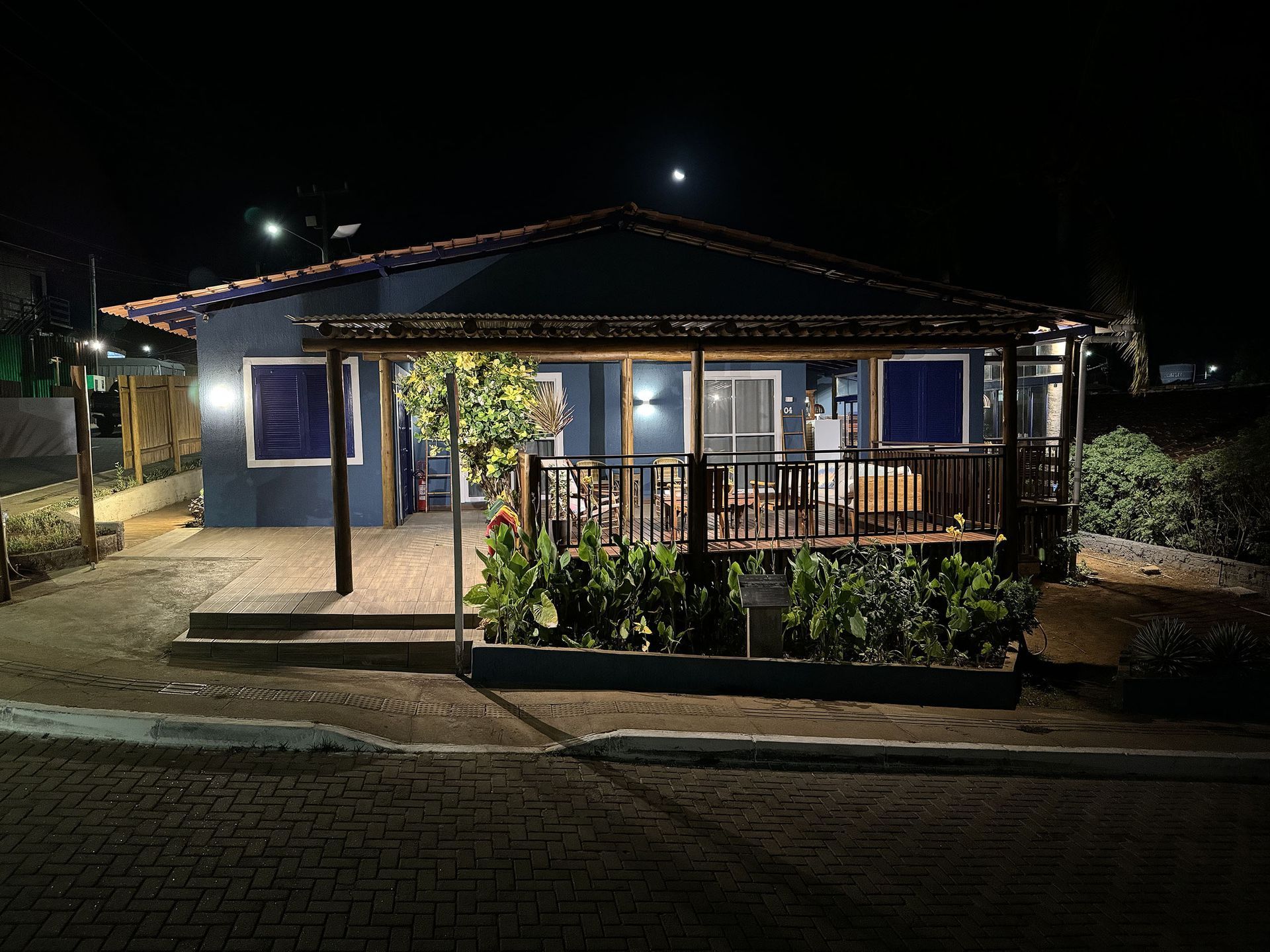 Uma casa com varanda é iluminada à noite.