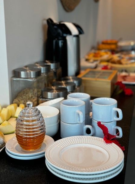 Pratos e xícaras em um balcão com um pote de mel